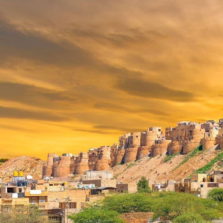 A scenic view of Jaisalmer Fort as seen from the road, highlighting its majestic presence against the backdrop of the surrounding landscape