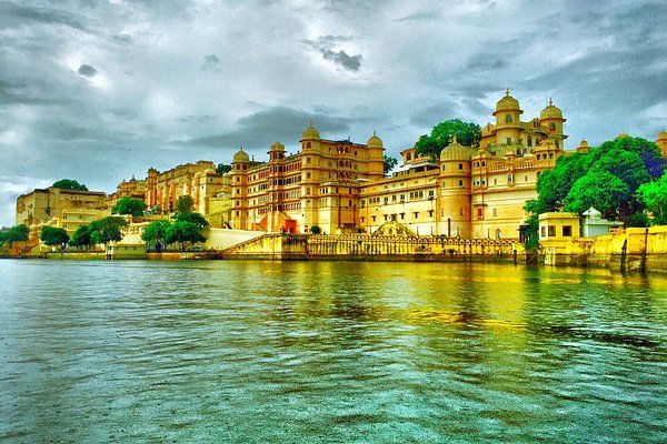 An enchanting view of Udaipur's City Palace adorned with green lights at night, creating a magical and vibrant atmosphere