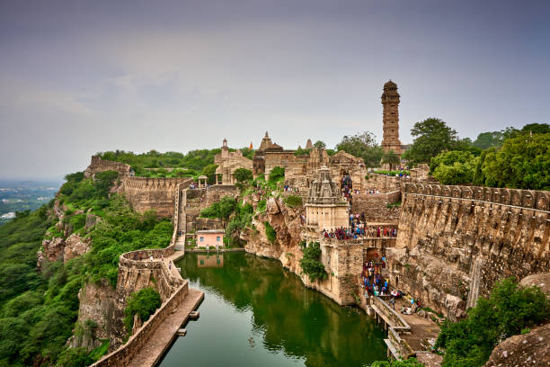 A picturesque scene of Chittorgarh Fort featuring the iconic Vijay Stambh and a tranquil pond, showcasing the historical and architectural richness of this fortress in Rajasthan, India