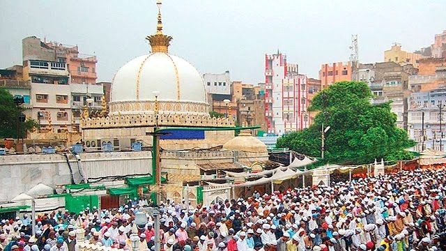 A group of devotees praying in front of the revered Ajmer Sharif Dargah, seeking blessings and solace in their faith