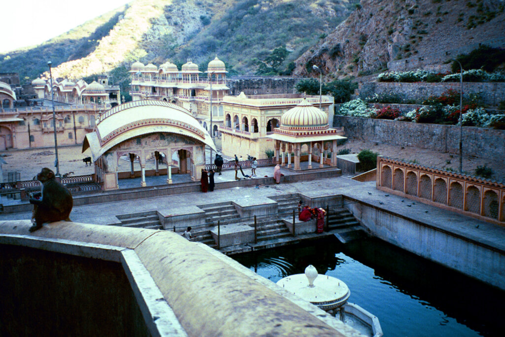 Scenic view of Galta Kund, a sacred Hindu pilgrimage site in Jaipur, Rajasthan, surrounded by lush greenery and historic architecture.