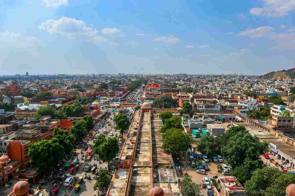 Aerial view of Jaipur city center with a prominent road surrounded by buildings and trees