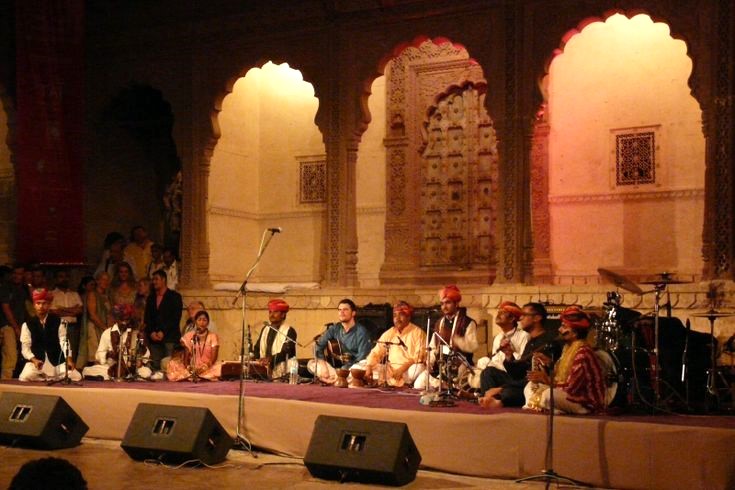 Artists sitting on stage and performing traditional Rajasthani songs during the Rajasthan International Folk Festival (RIFF).