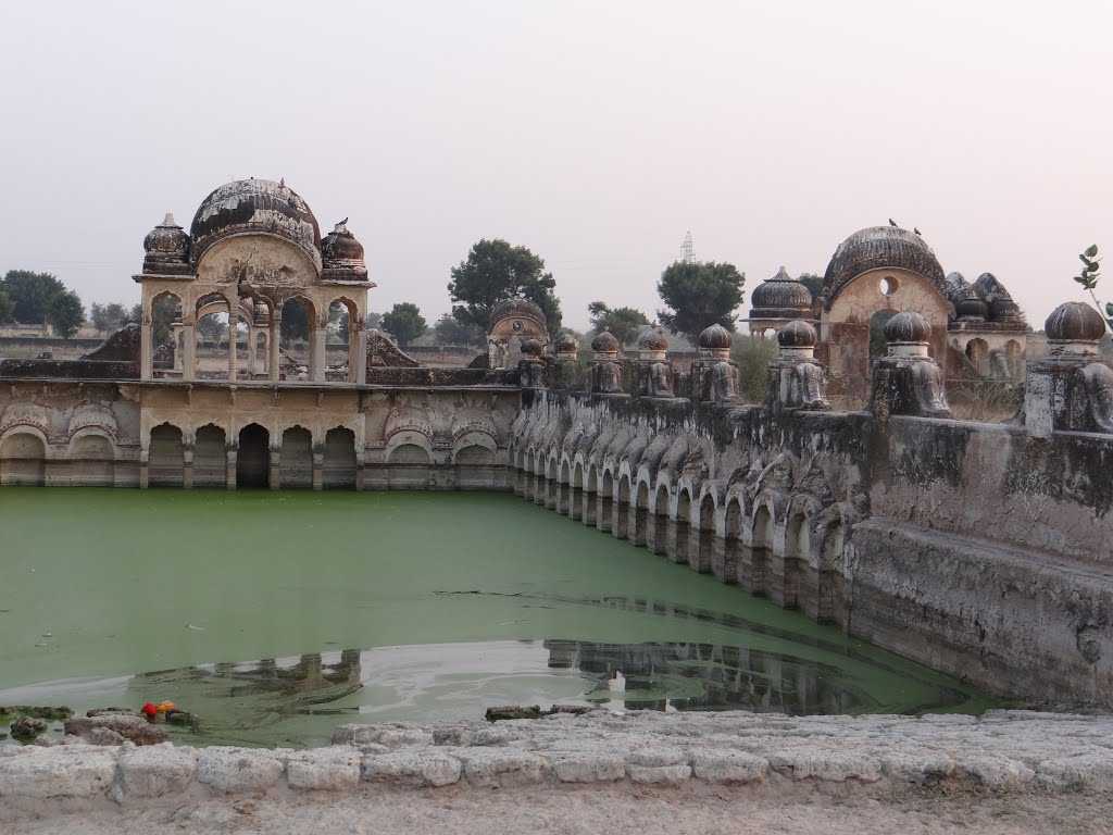 Sethani Ki Haveli in Churu, showcasing a water pond on the side with ancient architectural domes in the background.