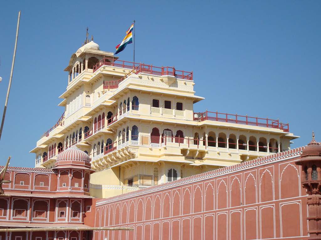 View of Chandra Mahal with a flag on the wall. Image sourced from Google Flickr.