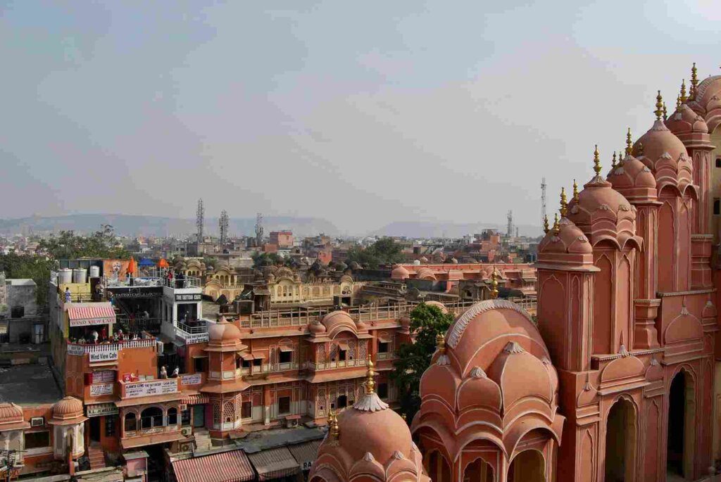 Hawa Mahal with bustling market and cityscape in the foreground, capturing the vibrant atmosphere of Jaipur. Photo by Indre Velaviciute on Unsplash.