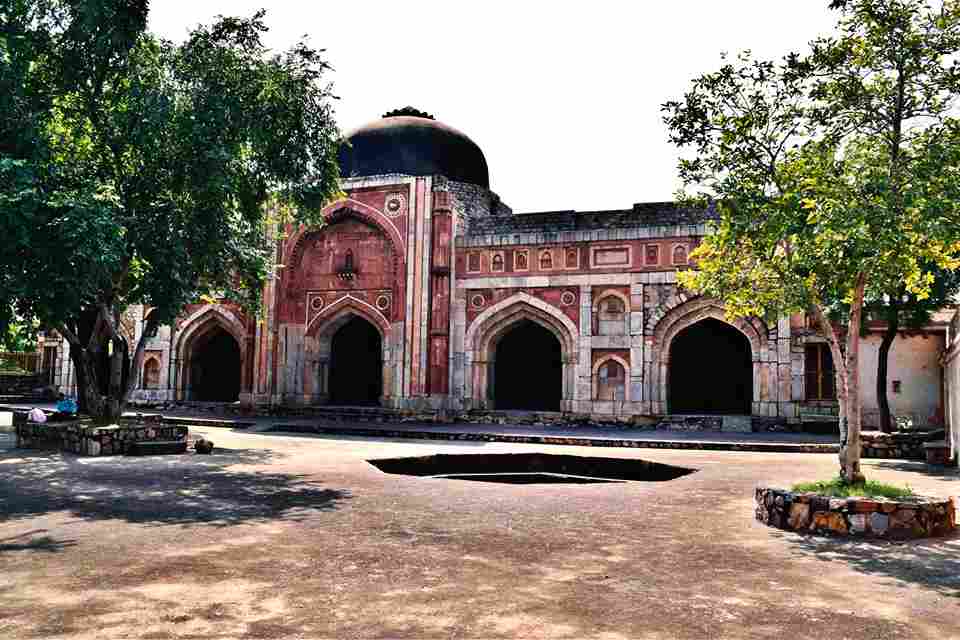 Jamali Kamali Mosque and Tomb" - Intricate marble structures amidst greenery.