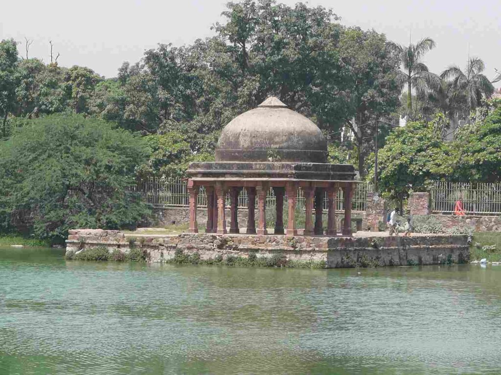 A scenic view of Mehrauli Archaeological Park in Delhi, showcasing ancient ruins and lush greenery.