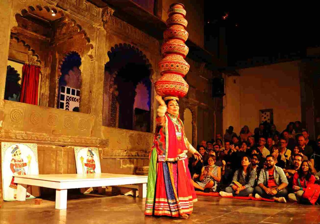 Bhawai dance performance in Rajasthan, India. Dancer balancing mitti ke ghare (earthen pots) on head while dancing. Colorful traditional attire. Wikimedia Commons.