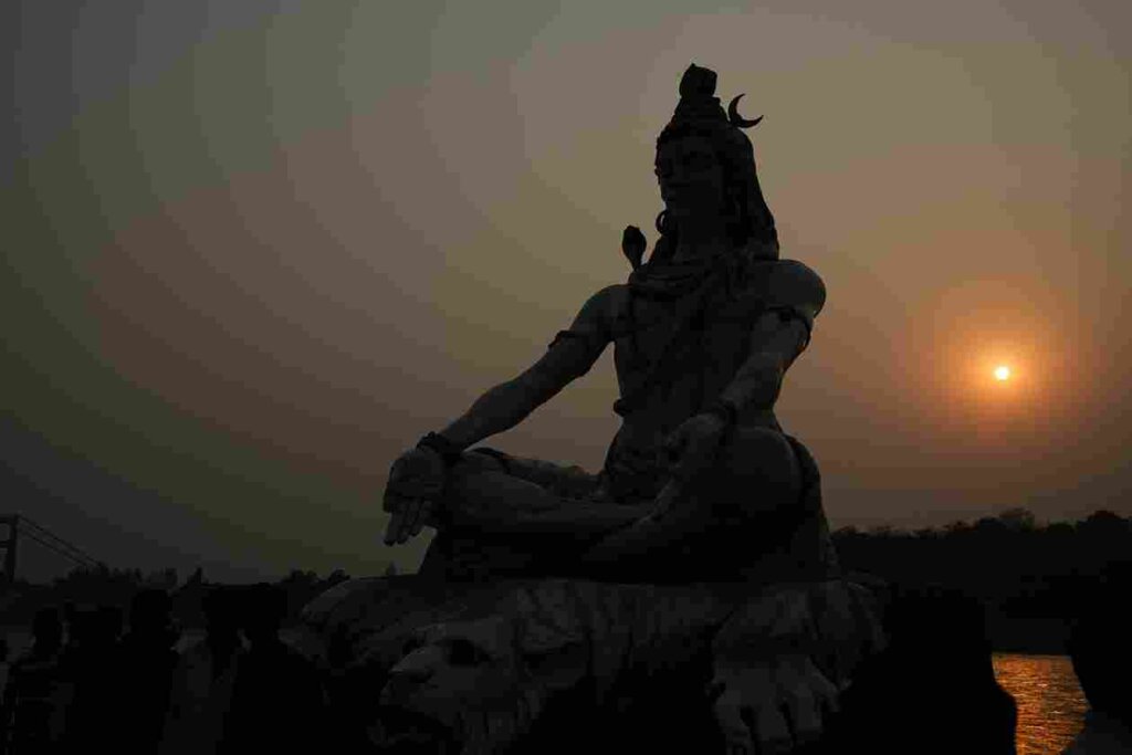 Silhouetted image of Lord Shiva's idol against a setting sun, capturing a mystical ambiance. Credit: Rahul Mishra on Unsplash.