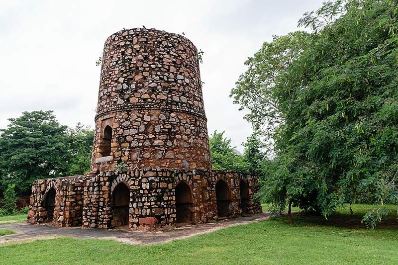 Chor Minar, Delhi" - A cylindrical tower with numerous holes, surrounded by trees, representing the historical landmark in Delhi known as Chor Mina