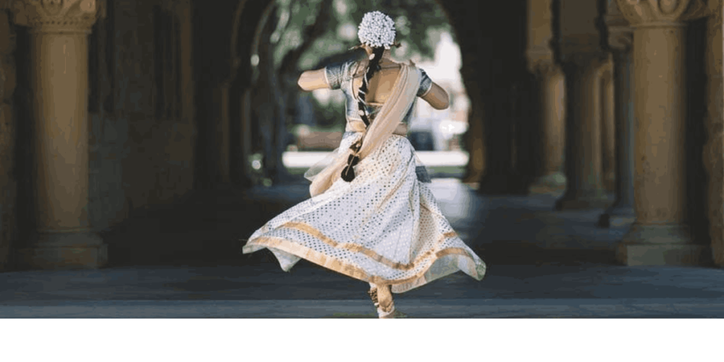 Image of a woman performing Ghoomar, a traditional Indian dance, captured from the back. Available on: Rawpixel.