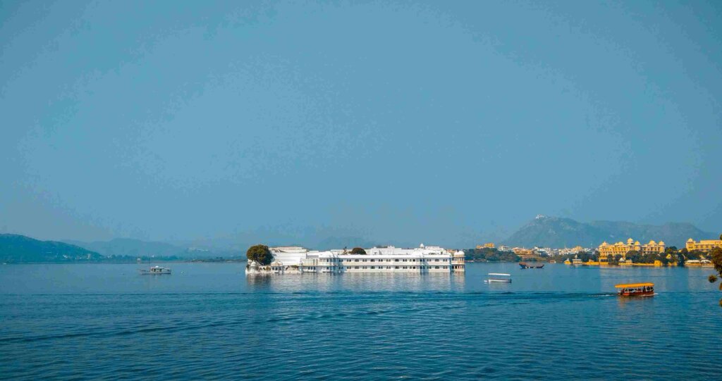 Tranquil lakeside scene with hotels and distant hills - Image by Siddharth Shah on Unsplash