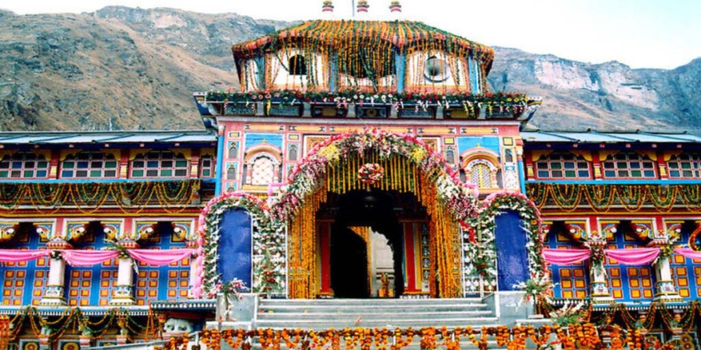 Badrinath Temple adorned with decorations, with mountain peaks in the background, captured beautifully in this image by Flickr.