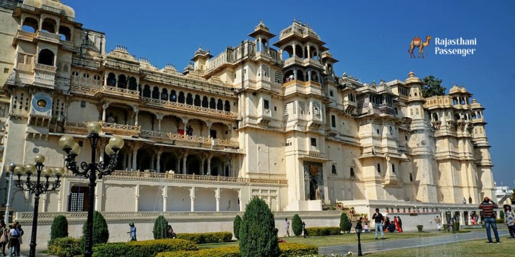 Exterior view of City Palace in Udaipur, Rajasthan, showcasing its stunning architecture amidst lush green gardens, capturing the essence of royal grandeur and natural beauty.