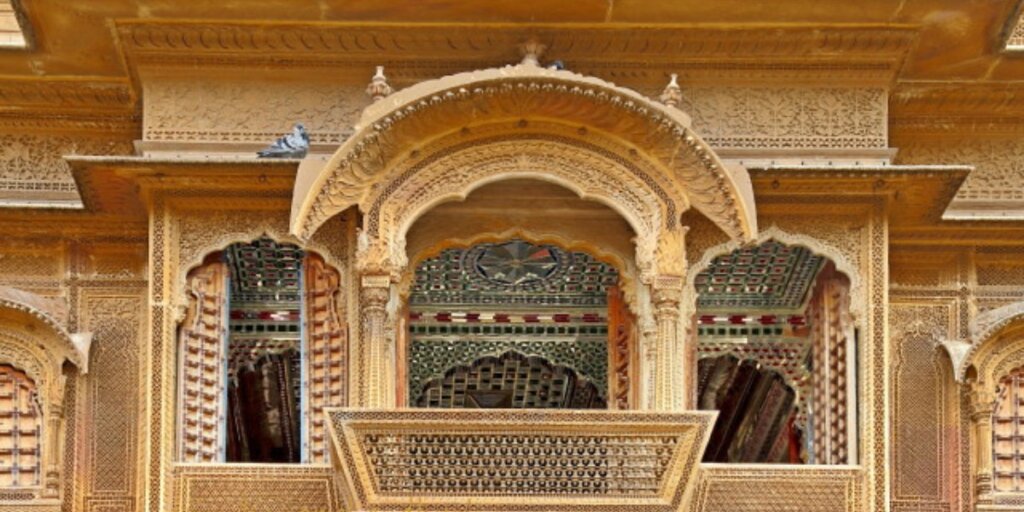 A captivating view of the intricately carved windows of Patwon ki Haveli in Jaisalmer, Rajasthan, showcasing the exquisite craftsmanship and architectural beauty of this historic mansion. Photo by Flickr.