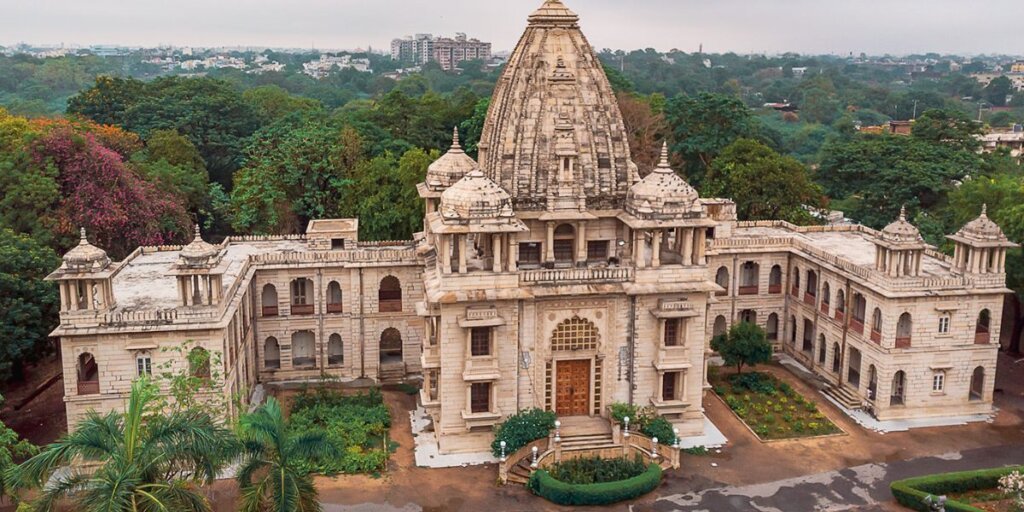 Exterior view of Kirti Mandir in Vadodara, showcasing its intricate architectural details and surrounding greenery.