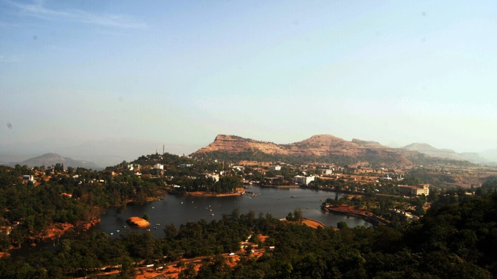 Saputara Lake, a serene body of water surrounded by lush greenery and hills, captured in an image sourced from Wikipedia.