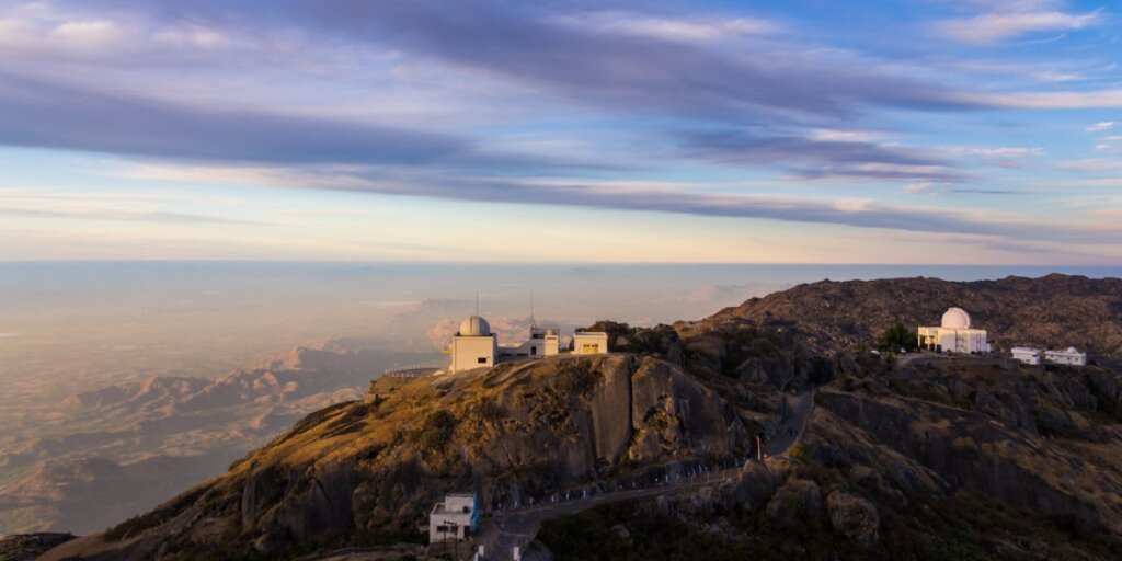 Scenic view of Guru Shikhar peak against a red evening sky in Mount Abu, Rajasthan. Image captured during sunset. Photo by Flickr.