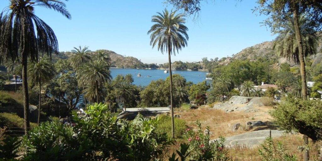  Nakki Lake in Mount Abu, surrounded by lush greenery and rocky hills, offering a serene and picturesque view.Image by Wikimedia Commons.