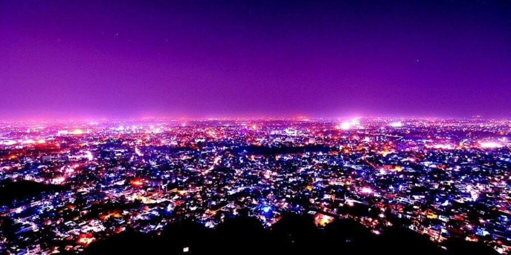 Breathtaking panoramic night view of the city skyline illuminated from Nahargarh Fort, offering a mesmerizing display of twinkling lights against the dark sky.