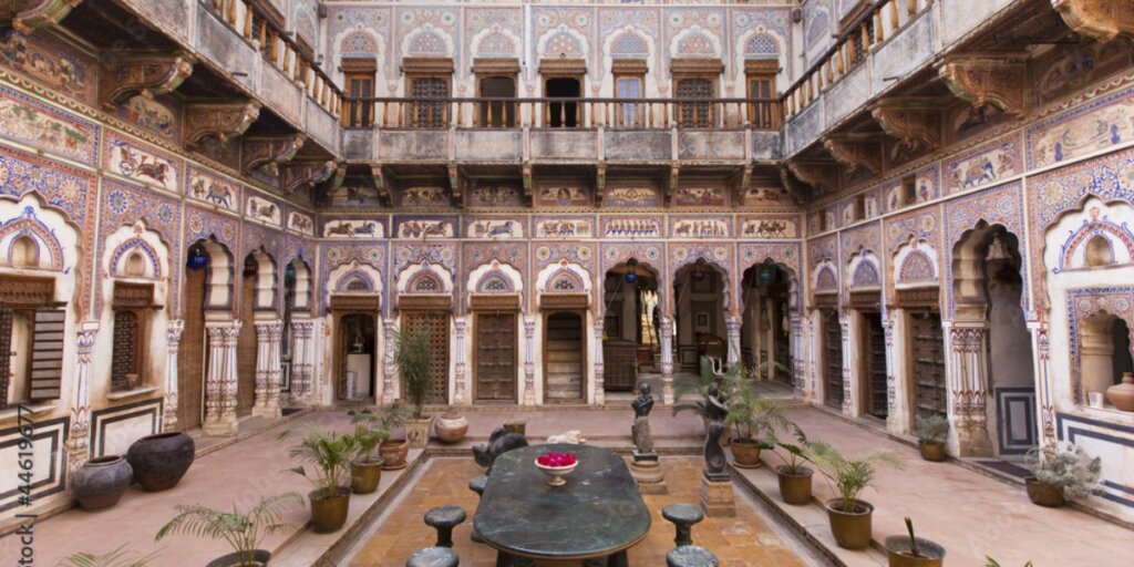 A view of the courtyard inside a mansion in Fatehpur, Shekhawati. The courtyard is decorated with colourful murals and intricate architecture, this fascinating artwork is a sight to behold Get this image on: Adobe Stock 