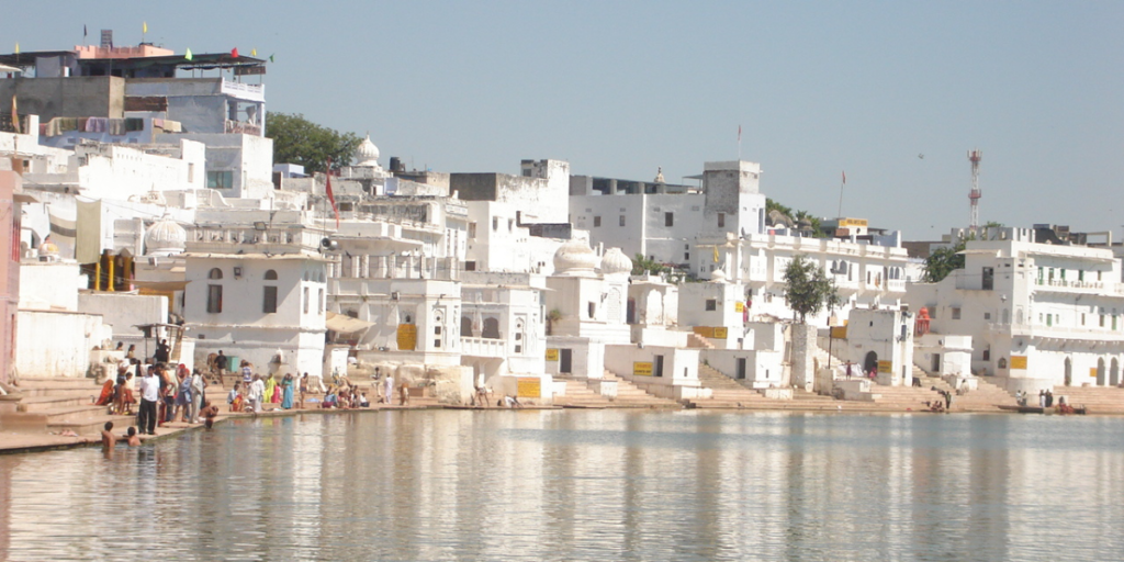 Pushkar Lake in Ajmer, surrounded by ghats and temples, is a sacred site for Hindu pilgrims. Image by Wikimedia Commons.